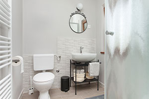 Open shelving, neutral colors, and a clean design help small bathrooms feel bigger.
